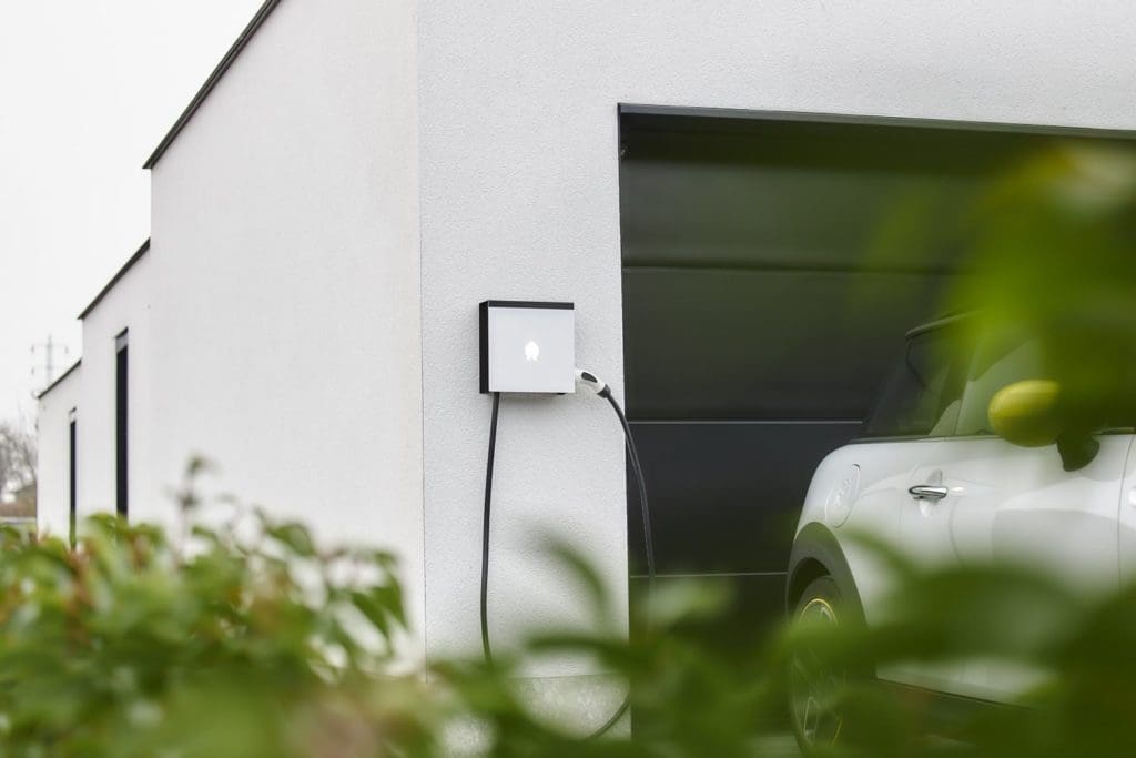 Smappee EV Wall home charger mounted on the side of a white wall garage