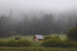 off grid house in the woods with solar power on the roof