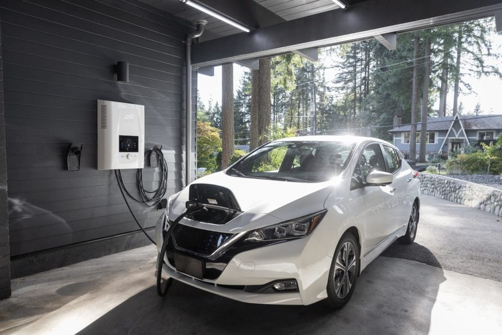 White electric vehicle pluged into ev charger