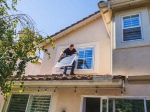Electrician on the roof fitting a solar panel