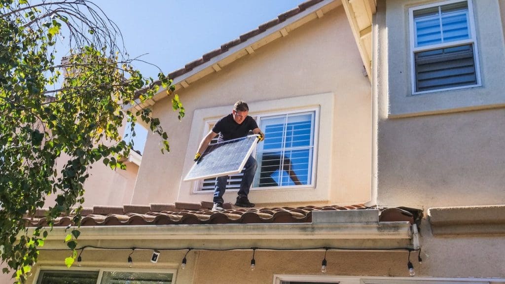 Electrician on the roof fitting a solar panel